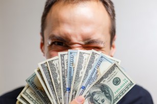 Portrait of a business man holding money isolated on white